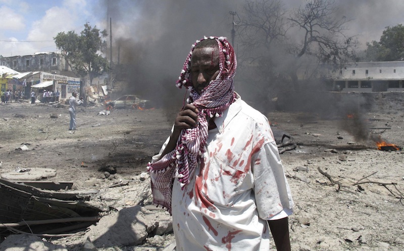 In this October 2011 file photo, a wounded man stands at the scene of an explosion in Mogadishu, Somalia in which 55 people were killed after the al-Shabab set off a car full of explosives in front of the Ministry of Education. The Islamic extremist group claiming responsibility for the weekend terrorist attack at a Kenyan mall presents a threat not just to the region or Africa but to the world at large, the president of Somalia said Monday on a trip to Ohio. (AP Photo/Mohamed Sheikh Nor, file)