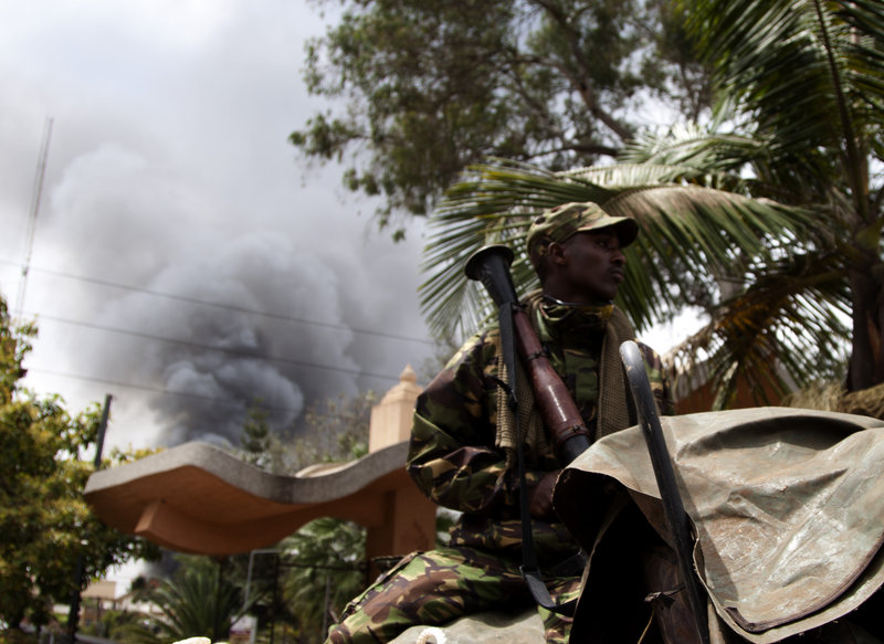 A soldier holds a RPG near the Westgate shopping mall in Nairobi, Kenya, as smoke rises from it, Monday Sept 23 2013. Islamic extremist gunmen lobbed grenades and fired assault rifles inside Nairobi's top mall Saturday, killing dozens and wounding over a hundred in the attack. A day after a Twitter post linked Maine to Saturday's terrorist attack in a mall in Nairobi, Kenya, law enforcement officials refused to say whether they are investigating the possibility that radical Islamist groups are trying to recruit new members in the state. (AP Photo/ Sayyid Azim)