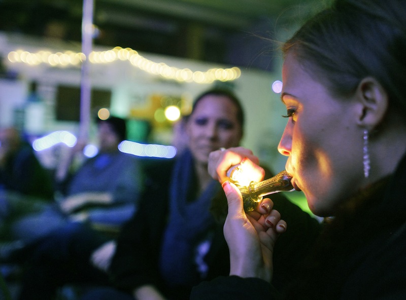 In this in Dec. 31, 2012 file photo, Rachel Schaefer of Denver smokes marijuana on the official opening night of Club 64, a marijuana-specific social club, where a New Year's Eve party was held, in Denver. Bolstered by political victories out West, a marijuana advocacy group is now looking at Maine and other New England states as fertile ground for its next major push to legalize a drug that's gaining wider acceptance from the American public.