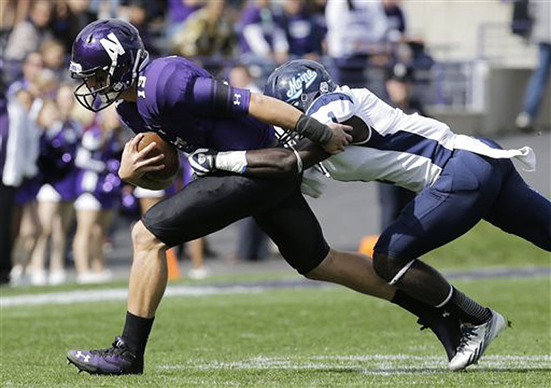 Maine defensive back Axel Ofori Jr. tackles Northwestern cornerback C.J. Bryant (13) during the first quarter of their game in Evanston, Ill., on Saturday. Northwestern won, 35-21