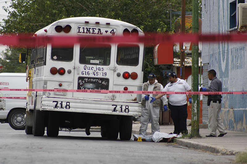 Forensic workers examine the scene where a bus driver was allegedly killed by a self-styled “bus driver hunter” in Ciudad Juarez, Mexico, on Aug. 28.