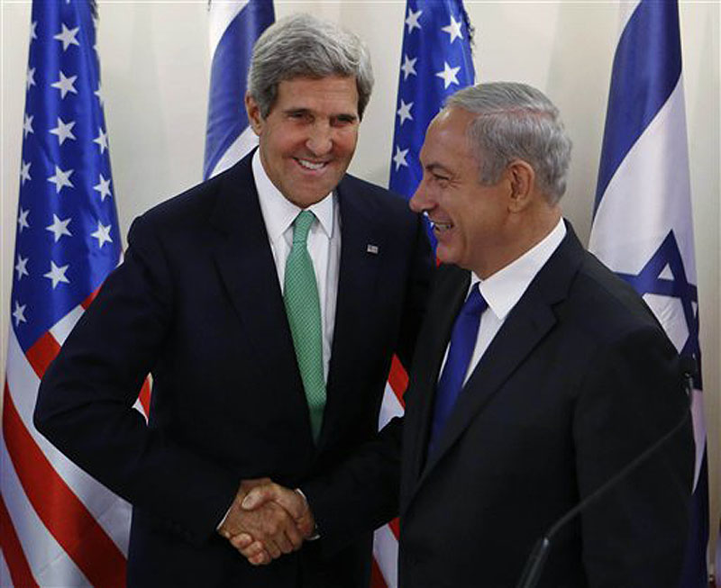 Secretary of State John Kerry shakes hands with Israel's Prime Minister Benjamin Netanyahu at the prime minister's office in Jerusalem on Sunday. Kerry sent a strong warning to Syria on Sunday, saying "the threat of force is real" if Syria does not carry out an internationally brokered agreement to hand over its chemical weapons. POOL PHOTO