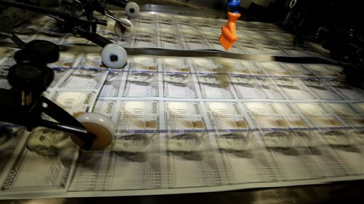 Sheets of uncut $100s run through a printing press at the Bureau of Engraving and Printing Western Currency Facility in Fort Worth, Texas.