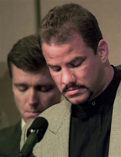 FILE - In this Feb. 15, 1996 file photo, heavyweight boxer Tommy Morrison, right, and promoter Tony Holden bow their heads during an emotional moment at a news conference about Morrison being HIV positive, in Tulsa, Okla. Morrison, a former heavyweight champion who gained fame for his role in the movie "Rocky V," has died. He was 44. Holden says his longtime friend died Sunday night, Sept. 1, 2013, at a Nebraska hospital.