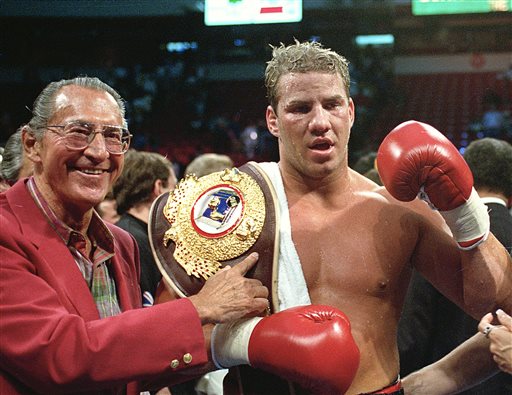 In this June 7, 1993 file photo, newly crowned WBO heavyweight champion Tommy Morrison receives his championship belt after defeating George Foreman in Las Vegas, Nev. Morrison, a former heavyweight champion who gained fame for his role in the movie "Rocky V," has died. He was 44. Morrison's former manager, Tony Holden says his longtime friend died Sunday night, Sept. 1, 2013, at a Nebraska hospital.