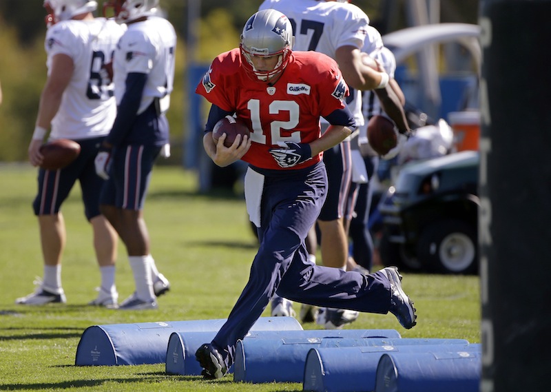 New England Patriots quarterback Tom Brady (12) runs a a drill during a stretching and drills session before practice begins at the NFL football team's facility in Foxborough, Mass., Wednesday, Sept. 25, 2013.