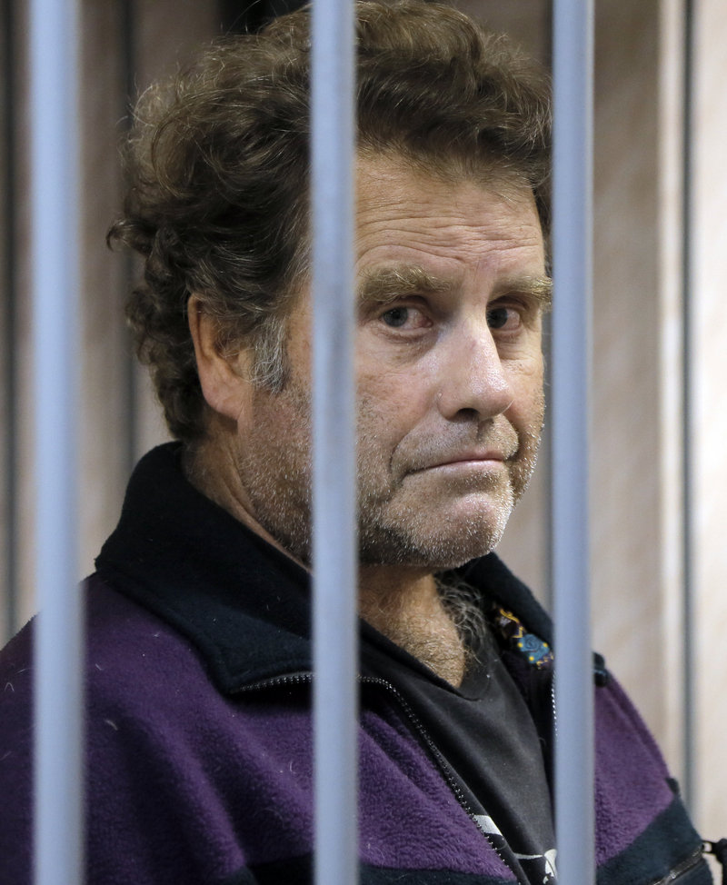 Peter Willcox, the captain of the Greenpeace ship Arctic Sunrise, is kept behind bars in a courtroom in Murmansk, Russia, on Thursday.