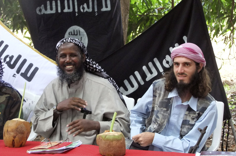 American-born Islamist militant Omar Hammami, right, and deputy leader of al-Shabab Sheik Mukhtar Abu Mansur Robow sit under a banner that reads "Allah is Great" during a news conference of the militant group in Somalia in May 2011. Hammami was killed Thursday in an ambush ordered by the militant group's leader, militants said.