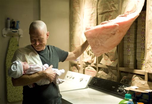 Walter White, played by Bryan Cranston, holds his daughter Holly while hiding money behind insulation in a scene from Season 2 of "Breaking Bad."