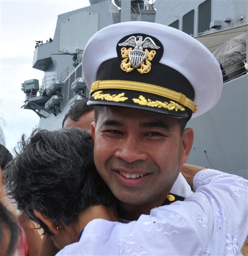 In this image provided by the U.S. Navy, Cmdr. Michael V. Misiewicz, then commanding officer of the guided-missile destroyer USS Mustin, is greeted by a member of his family as the Mustin arrives in Sihanoukville, Cambodia on Dec. 3, 2010.