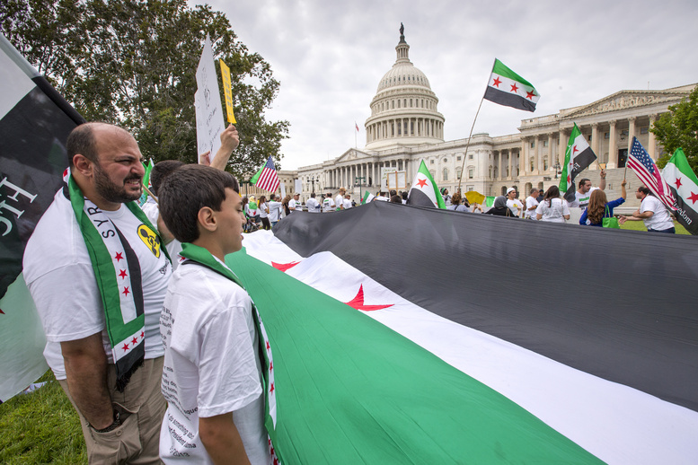 Waving the flag of the Syrian rebels, demonstrators opposed to the government of Syrian President Bashar Assad gather on the lawn of the U.S. Capitol in Washington on Monday.