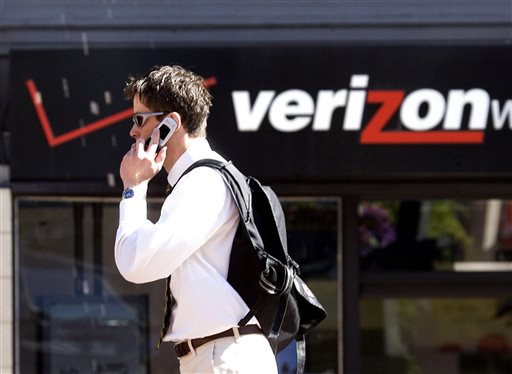 In this Monday, July 28, 2008, file photo, Eric Roden speaks on his cell phone as he walks past a Verizon store in Portland, Ore. Verizon says, Monday, Sept. 2, 2013, it has agreed to buy Vodafone's stake in Verizon Wireless for $130 billion.