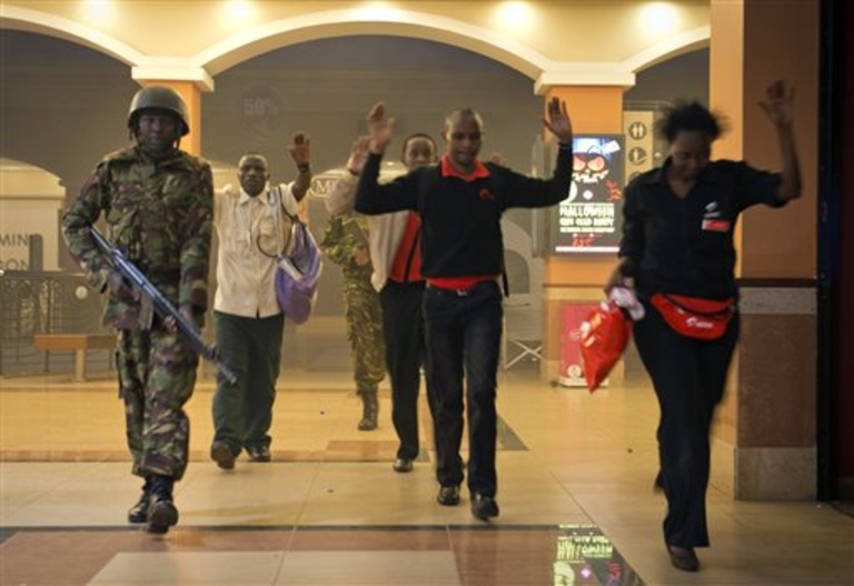 Civilians who had been hiding during a gun battle hold their hands in the air as a precautionary measure before being searched by armed police leading them to safety, inside the Westgate Mall on Saturday.
