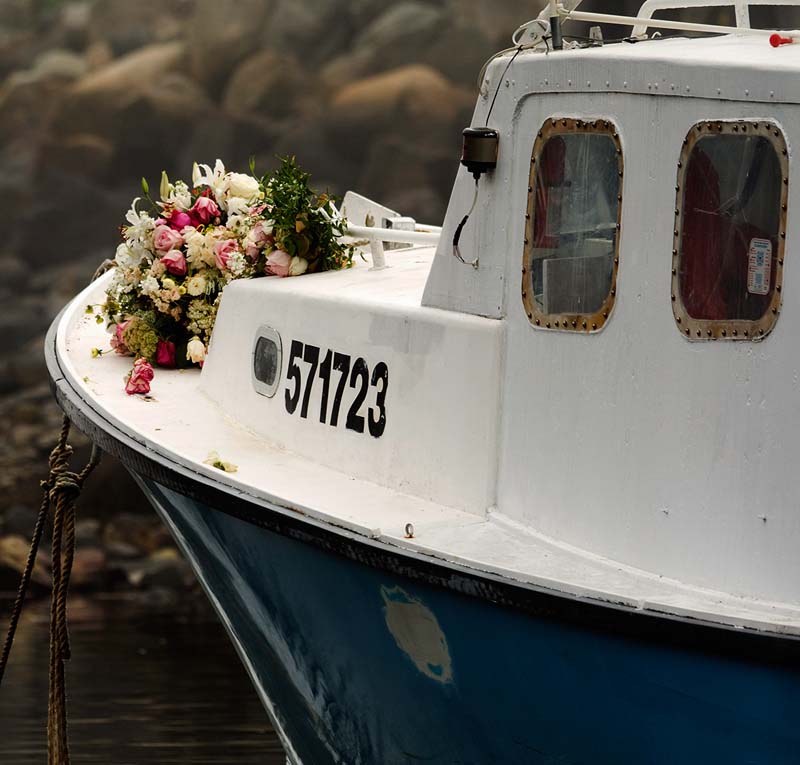 Bouquets of flowers rest on the bow of the lobster boat Clover in memory of Billy McIntire in Perkins Cove recently. McIntire and his friend Tim Levesque, along with three women, took the boat out late on the night of Aug. 22. “None of this should have happened,” said Levesque, adding, “I’m the one who had to say ‘bye’ to him and let him go.