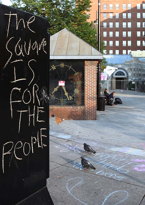A message written in chalk protesting the sale of part of Congress Square Plaza.