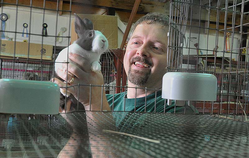 Chris Gurney, representing Archway Rabbitry in Minot, holds one of his Dutch rabbits, recognized as the oldest domesticated breed. Gurney exhibits and sells his rabbits.