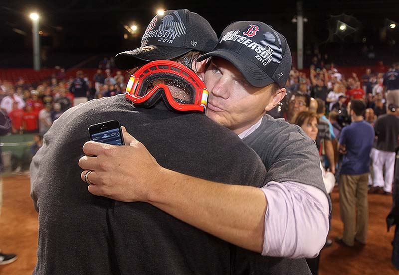 Boston Red Sox GM Ben Cherington, right, is embraced by one of his players after the Red Sox clinched the AL East title with a 6-3 win over the Toronto Blue Jays in a baseball game at Fenway Park on Friday night.
