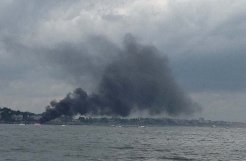 Heavy black smoke billows from a burning boat Sunday afternoon in Portland Harbor. Four people and a dog were rescued by a good Samaritan. No one was hurt.