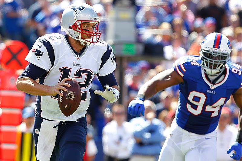 Patriots QB Tom Brady looks to pass as Buffalo's defensive end Mario Williams closes in during Sunday's game at Orchard Park, N.Y.