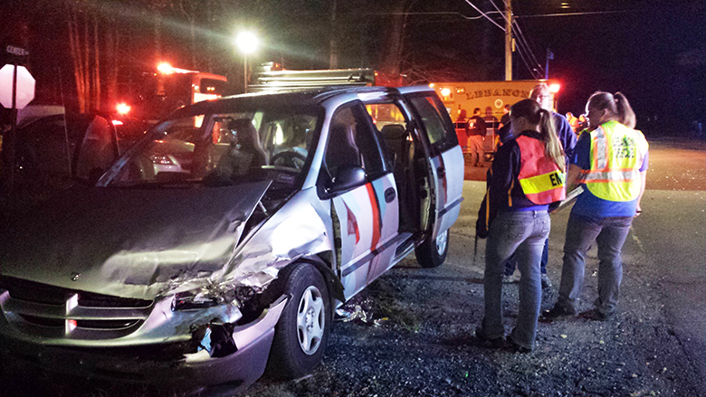 Emergency personnel examine one of the minivans involved in a collision on Center Road at the intersection of Lower Cross Road in Lebanon Monday night.