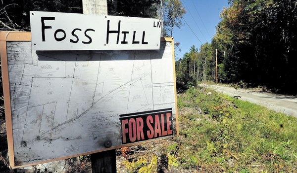 A sign at the end of the Foss Hill Lane in Rome lists several properties for sale.