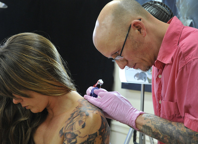 Chris Dingwell of Chris Dingwell Studio in Portland is part of the new wave of tattoo practitioners, college-educated businessmen with detailed professional portfolios. Dingwell, shown working with Jen Parker of Brattleboro, Vt., considers himself a tattoo “artist.”