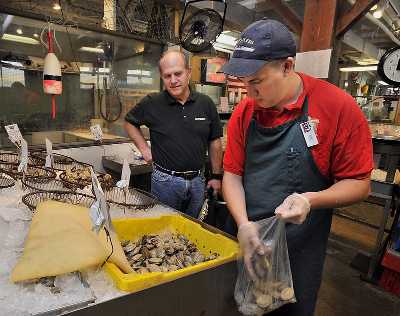Steve Ponichtera of Gladstone, N.J., watches as retail clerk Luke Parker fills a bag with steamers. Ponichtera said he makes frequent trips to Maine to attend antique auctions and rarely goes home without a selection of seafood from Harbor Fish Market.