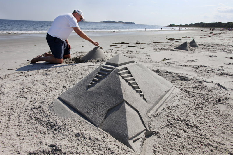 Scott Smyth of Falmouth works on sand sculptures Friday at Crescent Beach in Cape Elizabeth. Data show this summer has been pretty typical.