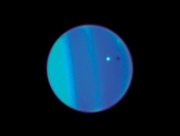 This Hubble Telescope image shows Uranus with its moon Ariel, a small white sphere. The discovery of Trojan 2011 QF99 was reported in the journal Science.