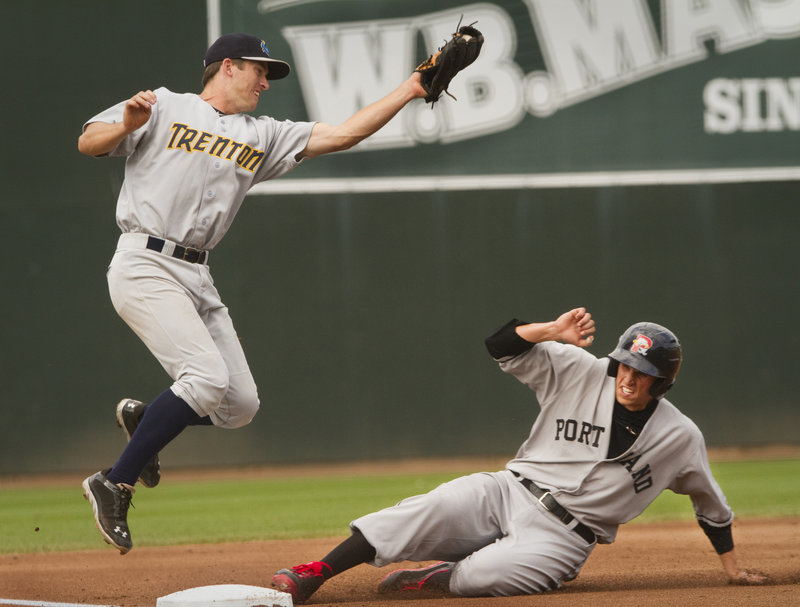 Garin Cecchini slides safely into third base, advancing from second on a wild pitch during the third inning of a 9-4 loss to the Trenton Thunder at Hadlock Field on Sunday. The Sea Dogs wore retro-style 1926 uniforms.