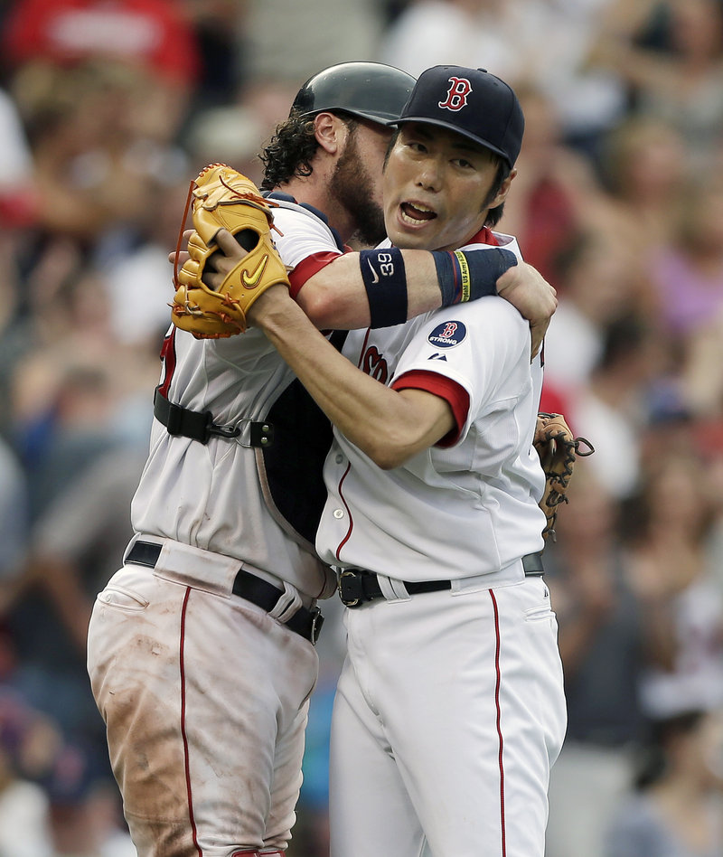 Boston’s Koji Uehara, right, celebrates with Jarrod Saltalamacchia after the Red Sox beat the White Sox 7-6 at Fenway Park on Sunday.