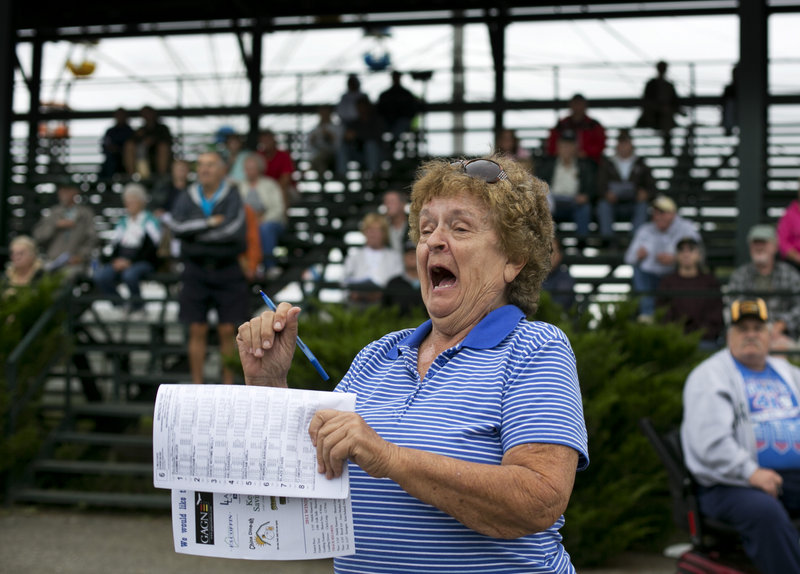 Sue Christiansen of Auburn cheers for a horse at the Windsor Fair on Thursday. Despite challenges, harness racing perseveres at many fairs and two tracks in Maine.