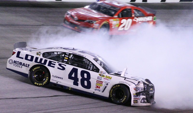 Jimmie Johnson slides through Turn 4 as Matt Kenseth safely gets by during Sunday’s race at Atlanta Motor Speedway.