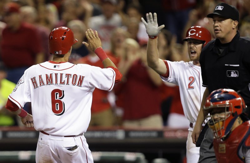Pinch-runner Billy Hamilton of the Reds gets congratulated by Zack Cozart after scoring the only run Tuesday night in Cincinnati’s win over visiting St. Louis.