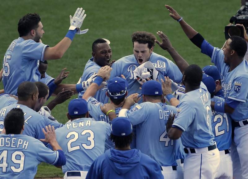Mike Moustakas, center, celebrates with his teammates after hitting a solo homer in the 13th inning to lift the host Kansas City Royals to a 7-6 victory over the Seattle Mariners.