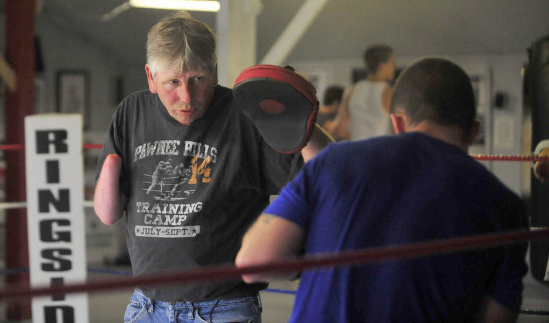 Skeet Wyman works with Brandon Berry to prepare him for the 12th annual Fight to Educate on Thursday.