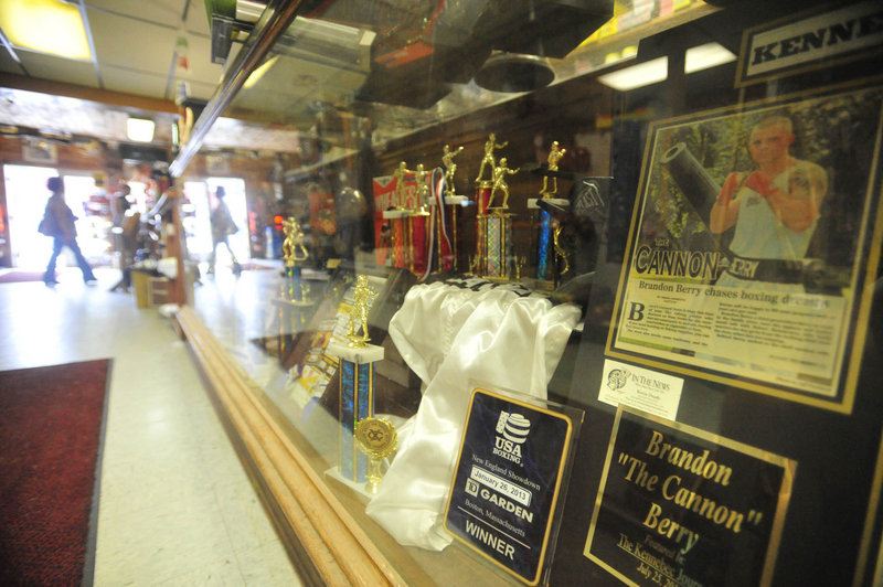A trophy case highlighting the boxing career of Brandon Berry lines the main aisle in the family’s store.