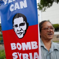 A demonstrator displays a placard during a protest against possible U.S. attacks on Syria, outside the U.S. embassy in Kuala Lumpur