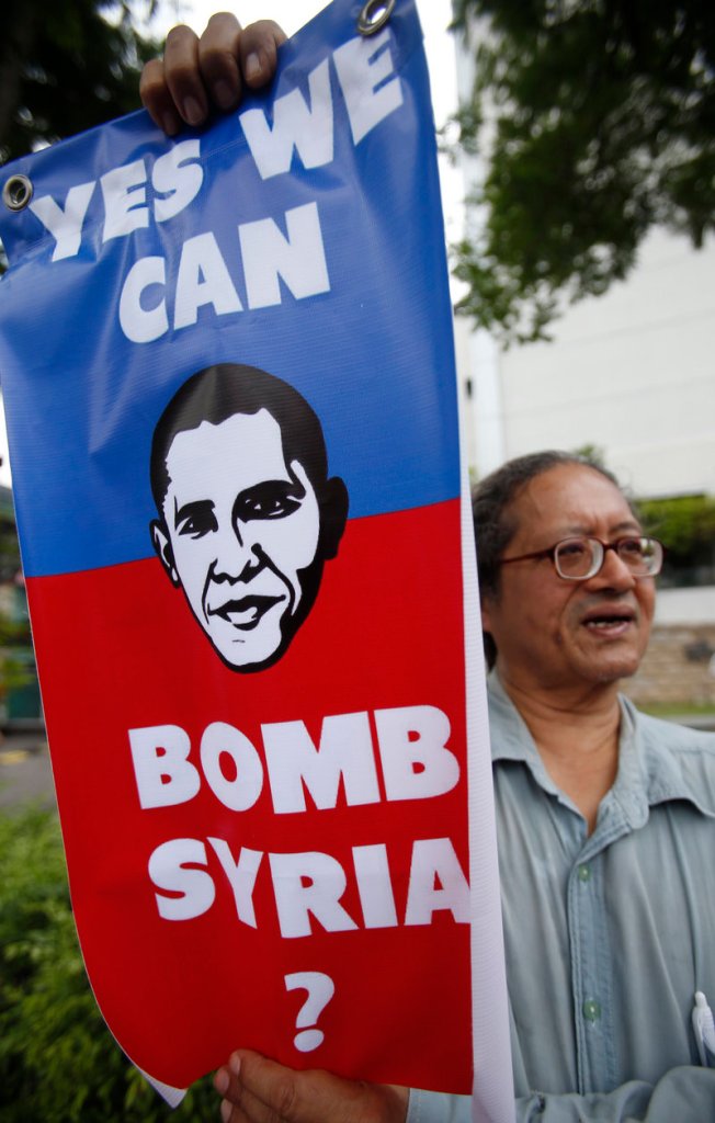 Protesters have been gathering around the world during the past week to speak out against a U.S. campaign against Syria. Here, a demonstrator displays a placard outside the U.S. embassy in Kuala Lumpur, Malaysia, on Friday.
