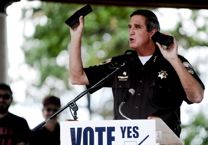 Weld County Sheriff John Cooke holds up two identical rifle ammunition magazines, one obtained legally and one obtained illegally, while making a speech last week to supporters of the recall election to oust Senate President John Morse, who voted for a 15-round limit on magazines.