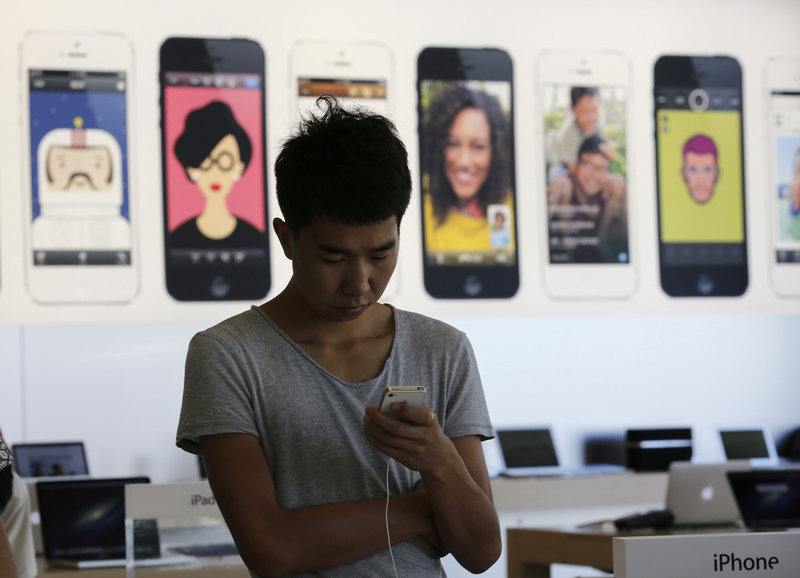 A man tries an iPhone at an Apple showroom in Beijing last week. There is speculation that Apple will unveil a gold version of the iPhone, which could be popular in China, where that color is considered a sign of good fortune.