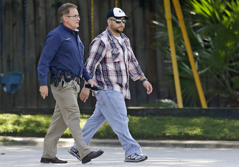 George Zimmerman, right, is escorted to a home by a police officer Monday in Lake Mary, Fla., after a reported domestic incident in the neighborhood where he and his wife had lived.