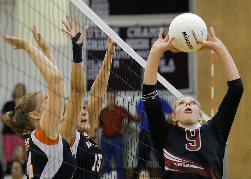 Kaylee Cimino of Greely sets the ball Tuesday night as Phoebe Robinson, left, and Bailey Cote of Biddeford prepare to block during Greely’s five-set victory in a high school volleyball match.