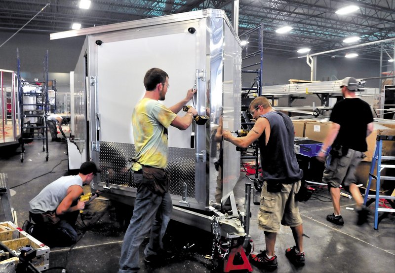 Alcom Inc. employees, from left, Alex Garceau, Jeff Buker and Jason Fecteau, make a snowmobile trailer at the Winslow plant. Alcom employs 185 people in Maine.
