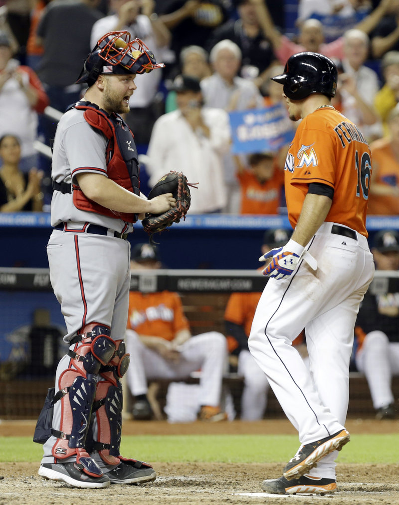 Atlanta catcher Brian McCann, left, and Miami pitcher Jose Fernandez exchange words after Fernandez hit a solo homer in Wednesday’s victory in Miami.