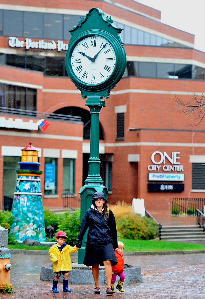 Laura Marston of Portland walks past the refurbished clock in City Center Plaza with her two children, Jack, 4, and Qunn, 2, after it was reinstalled Friday, Sept. 13, 2013.