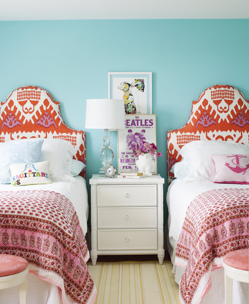 A girl’s room, as seen in Country Living magazine, features bright colors and headboards upholstered in a sophisticated ikat print.