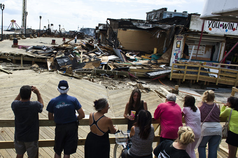 People look at the remnants of the boardwalk Friday after a massive fire in Seaside Park, N.J.