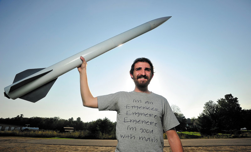 Mike Ostromecky, 22, of Winslow and six colleagues plan to launch an 18-foot, 500-pound rocket nearly 35 miles into the atmosphere this week. He designed the 5-foot rocket he is holding, which reached 2,000 feet.