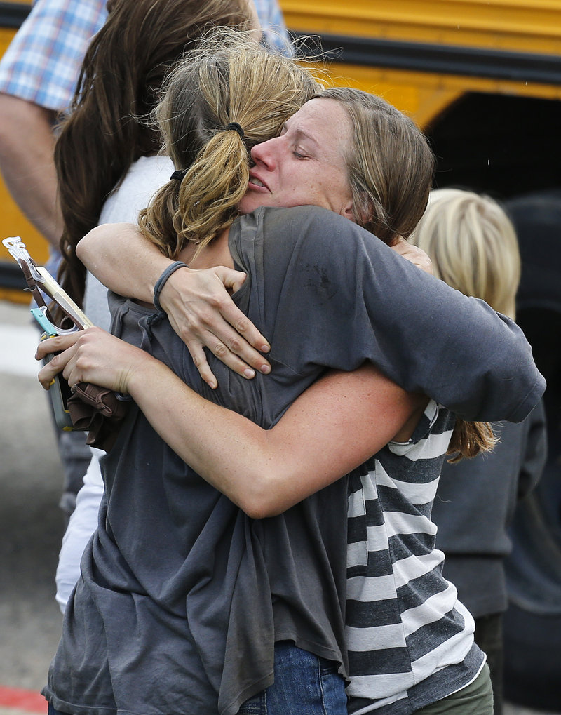 Evacuees hug at a school in Niwot, Colo., on Saturday, as the rescue of hundreds stranded by epic mountain flooding was accelerating.